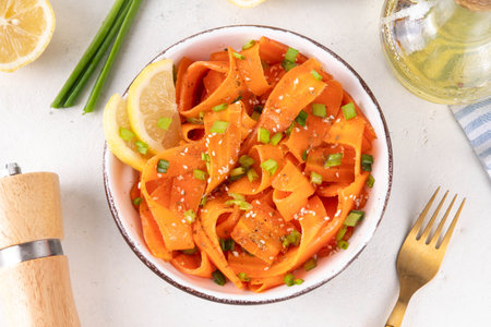 Viral trendy asian carrot salad with apple or wine vinegar, a little oil and salt, also known as Carrot Ribbon Salad. Trending carrot salad recipe, source of beta-carotene, healthy diet foodの写真素材