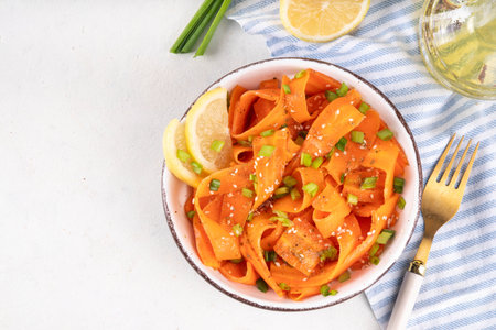 Viral trendy asian carrot salad with apple or wine vinegar, a little oil and salt, also known as Carrot Ribbon Salad. Trending carrot salad recipe, source of beta-carotene, healthy diet foodの写真素材
