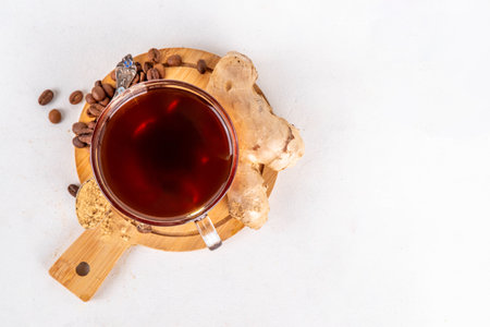 Fresh brewed ginger coffee cup. Dark coffee espresso hot drink with ginger powder and ginger root, on white background. Healthy hot drink. alternative medicine, remedyの写真素材