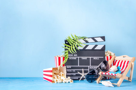 Summer holiday and vacation movie cinema marathon background Cinema clapper-board with sunglasses, seashells, starfish, popcorn buckets, vacation accessories, Cinema for the summer Movie Night partyの写真素材