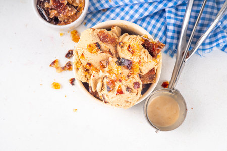 Creme brulee ice cream topped with caramelized sugar, sweet creamy gelato with a lot of crunchy caramel pieces and extra portion on topの写真素材