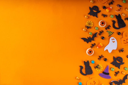 Halloween bright holiday background with traditional holiday symbols - pumpkins, ghost, black cat, witch hat, spiders. Halloween invitation, greeting card background top view copy spaceの写真素材