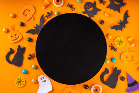Halloween bright holiday background with traditional holiday symbols - pumpkins, ghost, black cat, witch hat, spiders. Halloween invitation, greeting card background top view copy spaceの写真素材