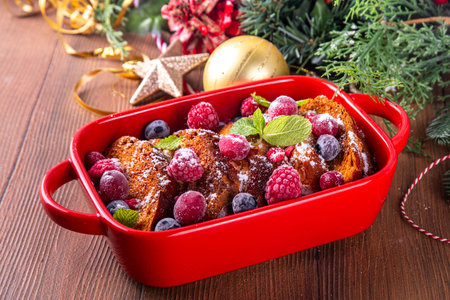 Christmas Morning French Toast Baking, holiday morning french toast casserole, sweet simple dessert with bread, egg and milk mixture and fresh berriesの写真素材