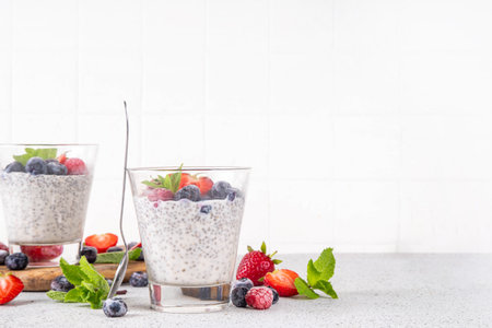 Chia seeds pudding with fresh berries. Healthy summer breakfast dessert with creamy milk or yogurt, chia, strawberry and blueberry, white table background copy spaceの写真素材
