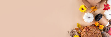 Autumn cozy background with autumn hat, bag, plaid, paper cup of coffee or tea, autumn leaves and pumpkins, beige background top view copy spaceの写真素材