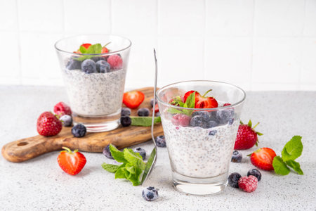 Chia seeds pudding with fresh berries. Healthy summer breakfast dessert with creamy milk or yogurt, chia, strawberry and blueberry, white table background copy spaceの写真素材
