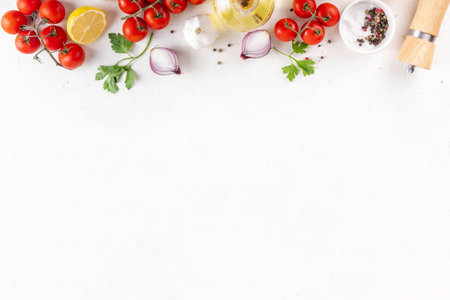 Spices, black pepper, garlic, onion, greens and tomatoes, olive oil on white cooking table. Ingredients for cooking food on the white stone concrete background top view copy space.の写真素材