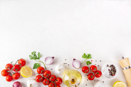 Spices, black pepper, garlic, onion, greens and tomatoes, olive oil on white cooking table. Ingredients for cooking food on the white stone concrete background top view copy space.の写真素材