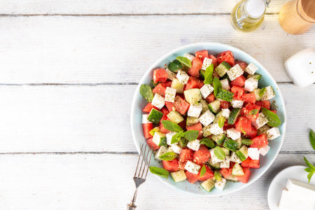 Viral summer Watermelon Salad with slices red watermelon, cucumber, white feta or tofu cheese, herbs, with olive oil and spices, copy spaceの写真素材