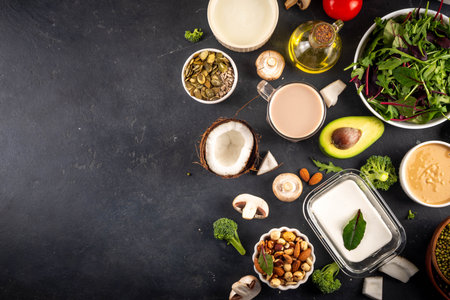 Plant based keto food background with, low carb vegan keto diet ingredients, healthy vegetarian fat and protein source. Assortment green vegetables, nuts, legumes, oil, coconut, nuts, peanut butterの写真素材