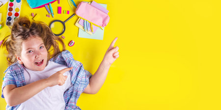 Cute emotional girl ready to back to school with various school supplies, education accessories on bright yellow backgroundの写真素材