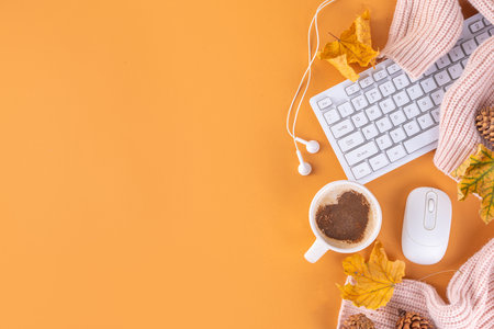 Autumn holidays cozy background, cozy flat lay with coffee latte cup with heart decor, computer laptop keyboard, earphones, warm sweater or plaid, fall leaves, on beige background top view copy spaceの写真素材