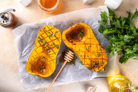 Baked pumpkin butternut squash with honey, spices and autumn herbs,  sweet roasted butternut pumpkin for cooking dishes and dessertsの写真素材