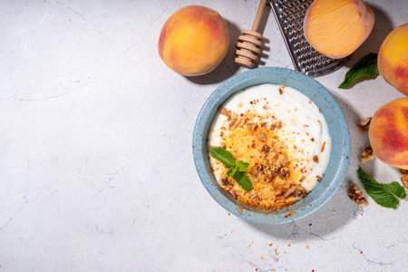 Frozen Shaved Peaches and Cream Dessert, Healthy summer snack with cream or yogurt and shaver frozen peach fruits, with nuts, honey and mint, copy spaceの写真素材