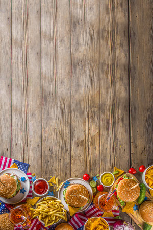 Celebrating Independence Day, July 4. Traditional American Memorial Day Patriotic Picnic with burgers,  french fries and snacks, Summer USA picnic and bbq concept, Old wooden backgroundの写真素材