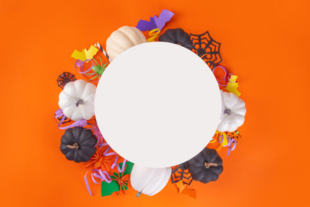 Halloween high-colored yellow background with colorful party holiday accessories and decor, spiders, cobwebs, pumpkins, bats, ghosts, top view flat lay copy spaceの写真素材