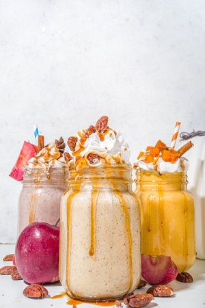 Apple, pumpkin and pecan pie smoothie drinks. Traditional autumn baking cake flavor cocktails set, on white background copy spaceの写真素材