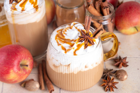 Apple pie spices latte drink, cosy autumn warm coffee beverage with apple pie syrup and spices, with fresh red apples, cinnamon, anise, copy spaceの写真素材