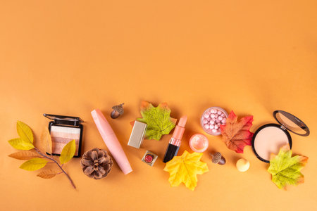 Autumn makeup cosmetics set with cozy beige background with autumn leaves, fall cosmetics sales, autumn seasonal style outlook and makeupの写真素材