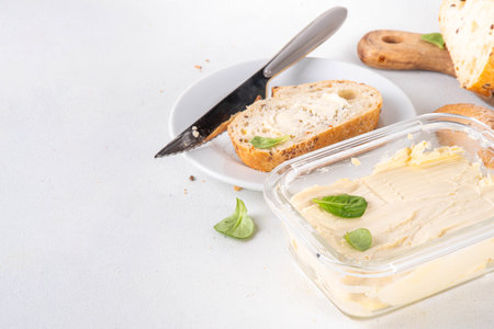 Homemade Vegan Butter, non-dairy creamy, plant based alternative butter with soy bean leave, and home baked bread on kitchen white table backgroundの写真素材