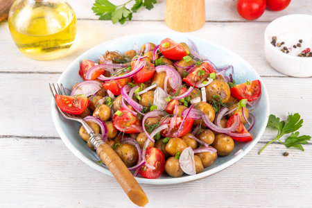 Summer young potatoes salad, with baby potato, onions, tomatoes, olive oil. Summer barbeque and picnic recipe ideas, vegan comfort foodの写真素材