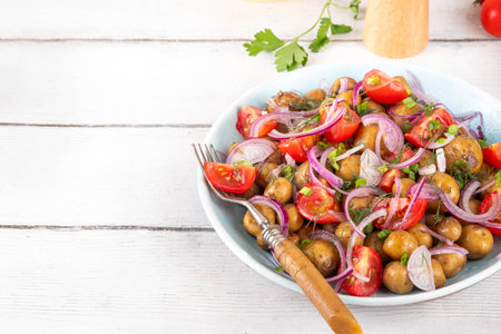 Summer young potatoes salad, with baby potato, onions, tomatoes, olive oil. Summer barbeque and picnic recipe ideas, vegan comfort foodの写真素材