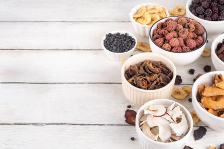 Freeze-Dried Fruits berry, alternative way to store summer harvest. Bowls with dried dehydrated raspberry, blueberry, peach, banana, apricot, plum, blackberry, apple, cherry on white wood backgroundの写真素材