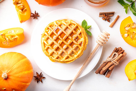 Autumn breakfast dessert, pumpkin waffle. Stack of homemade belgian pumpkin waffles with honey and spices, copy spaceの写真素材
