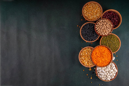 Various dried  beans, lentils, mung, chickpea, pea  assortment in wooden bowls. Legumes on white...