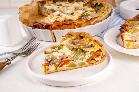 Slice of freshly baked homemade pie quiche lorraine on white table, top view, copy space. Vegan...