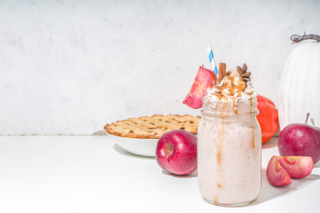 Apple pie smoothie. Crazy shake cocktail with traditional autumn apple pecan flavor, white background copy spaceの写真素材