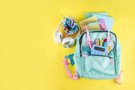 Back to school colorful background containing various school supplies, education accessories for students and school kids, notebooks, pens, pencils, calculator, pencil case, backpack, headphonesの写真素材