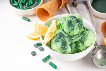 Vegan protein and superfood dessert, Frozen spirulina smoothie, green spirulina ice cream in ceramic bowl, sweet tasty low-calorie healthy summer dessert with green algae and lemonの写真素材