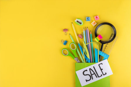 Back to school sale and shopping concept. Variety of school stationery in shopping bag pencils,...