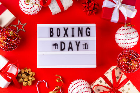 Boxing day sale seasonal promotion background with various wrapped presents gift boxes, baubles,...