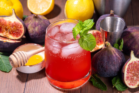 Iced figs lemonade cocktail, autumn fruit cold drink with fig juice, mint, lemon and honey, sweet and tasty autumn party alcohol beverageの写真素材