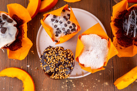 Tasty autumn chocolate pumpkin cupcakes, chocolate and sugar glazed muffins with various fillings, sweet autumn seasonal dessertの写真素材