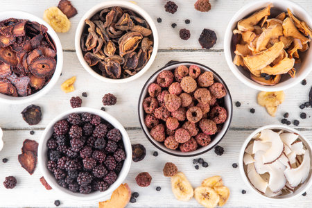 Freeze-Dried Fruits berry, alternative way to store summer harvest. Bowls with dried dehydrated raspberry, blueberry, peach, banana, apricot, plum, blackberry, apple, cherry on white wood backgroundの写真素材