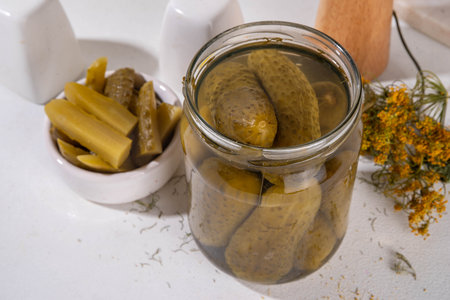 Homemade pickles in jar. Tasty gourmet pickled cucumbers with spices on kitchen table background copy spaceの写真素材