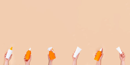 Summer vacation sun protection concept. Women's, children's hands with different tubes, jars, bottles, sprays of sunscreen products. Chemical and natural SPF products, UVA UVB sun protect backgroundの写真素材