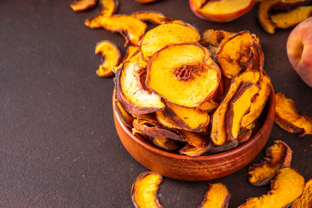 Homemade sun dried sublimated slices of peach, dehydrate peach fruits for eating healthy sweet snacks, fruit chips, ingredient for cooking and desserts. Alternative preservation without sugarの写真素材