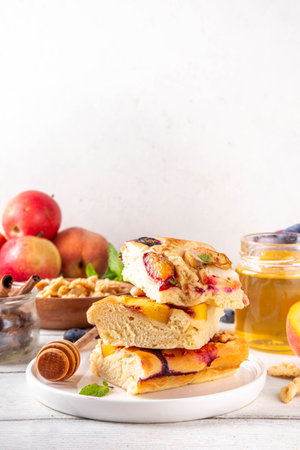 Tasty fruit dessert Focaccia. Sweet viral italian Focaccia open pie, with various seasonal autumn and summer fruits - plum, apple, figs, apricot, blueberry, peach and nuts, with spices and honeyの写真素材