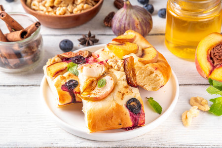 Tasty fruit dessert Focaccia. Sweet viral italian Focaccia open pie, with various seasonal autumn and summer fruits - plum, apple, figs, apricot, blueberry, peach and nuts, with spices and honeyの写真素材