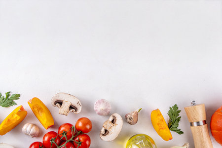 Autumn vegetable preparation dinner background. Food background with organic fresh farm raw veggies, pumpkin, garlic, mushrooms, tomato, greenery, Ingredients for cooking with copy spaceの写真素材