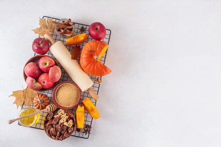 Fall baking, cooking seasonal dessert background with various ingredients - honey, pumpkin squash, brown sugar, cinnamon, spices, red apples, walnuts, pecans. Autumn, thanksgiving bakery backgroundの写真素材