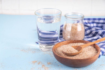 Whole Psyllium Husk in spoon, bowl and jar, with glass of water, natural alternative to pills or...