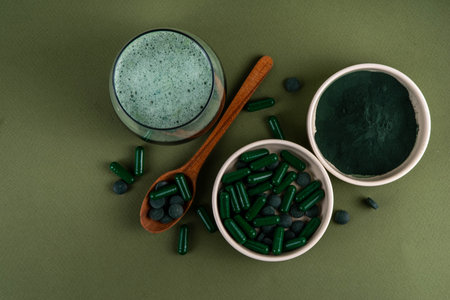 Spirulina in powder, capsules and pills with spirulina smoothie or infused water drink. Natural organic superfood, plant protein amino-acids source, in different forms, copy spaceの写真素材