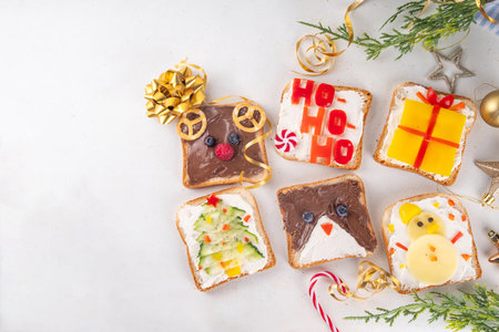 Christmas funny creative toasts sandwich for kids breakfast. Homemade Christmas morning sandwiches in form of gift, Christmas tree, deer, snowman, penguin, with cheese, fruit, chocolate, vegetablesの写真素材