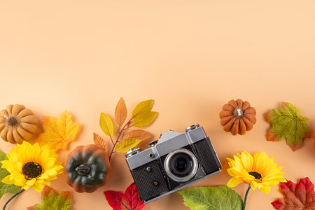Fall seasonal walking leisure background with autumn leaves, sunflower flowers, pumpkins, warm blanket, hat, knitted bag, coffee cup, photo camera. Comfortable autumn leisure backgroundの写真素材